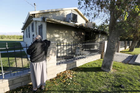 A member of the Islamic Society of Coachella Valley stands watch December 12, 2015 after a fire burned the lobby of the building. REUTERS/Sam Mircovich