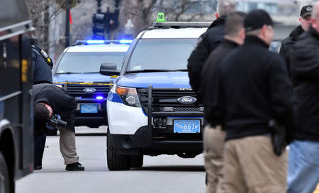 A Boston Police crime scene investigator photographs evidence at the scene after a burning propane tank was left near an unoccupied police cruiser in Boston, Massachusetts, U.S., January 20, 2017. REUTERS/Josh Reynolds