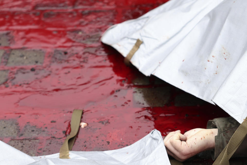 The hand of a victim lays in a pool of blood after a Russian attack in Odesa, Ukraine, Friday March 15, 2024. A Russian missile strike on Odesa in southern Ukraine on Friday killed at least 14 people and injured 46 others, local officials said. A first missile struck houses and when emergency crews arrived at the scene a second missile landed, authorities said. (AP Photo/Victor Sajenko)