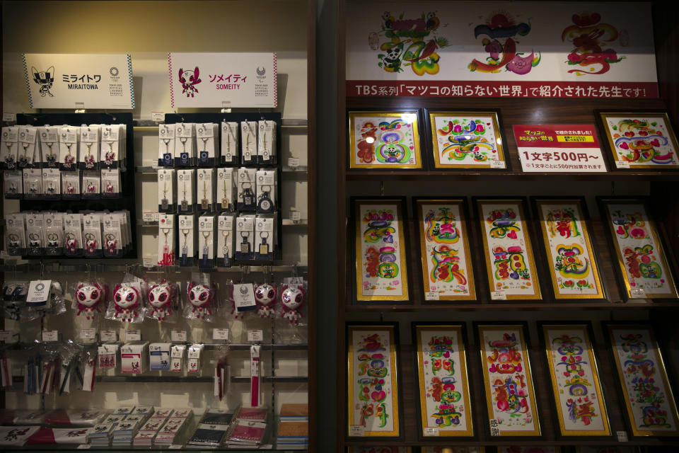 In this Feb. 13, 2020, photo, Tokyo 2020 souvenirs and calligraphy prints are for sale at a gift shop in Yokohama's Chinatown, near Tokyo. A top Olympic official made clear Friday the 2020 Games in Tokyo will not be cancelled despite the virus that has spread from China. (AP Photo/Jae C. Hong)