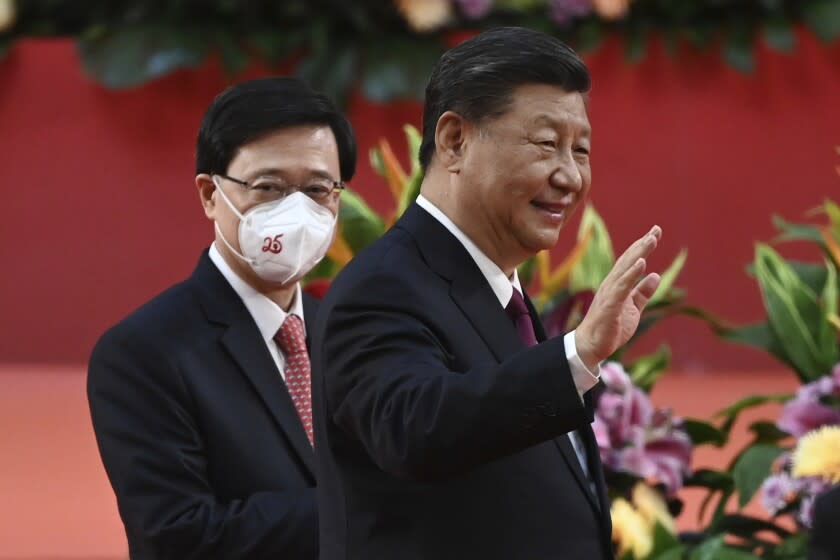 Hong Kong's new Chief Executive John Lee, left, walks with China's President Xi Jinping following Xi's speech after a ceremony to inaugurate the city's new leader and government in Hong Kong Friday, July 1, 2022, on the 25th anniversary of the city's handover from Britain to China. (Selim Chtayti/Pool Photo via AP)