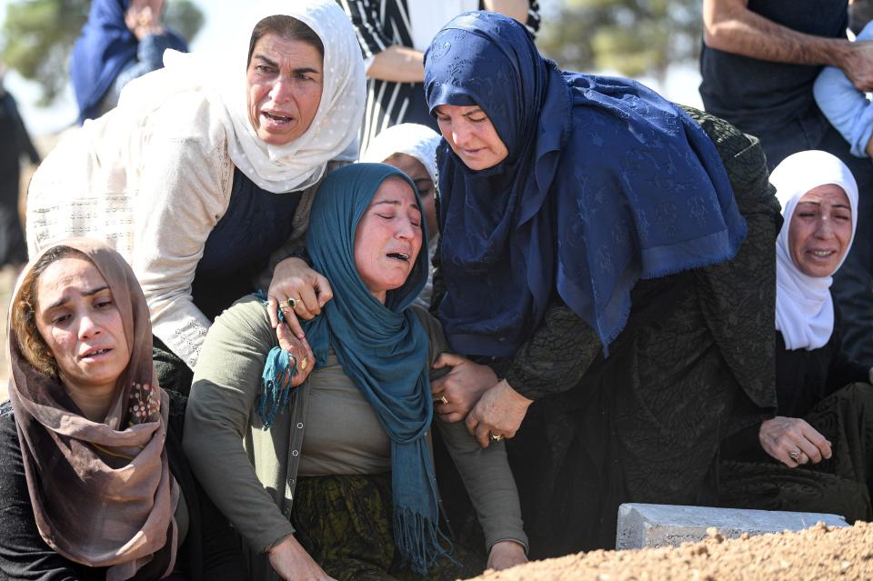 Relatives mourn in front of the grave of Halil Yagmur who was killed in a mortar attack a day earlier in Suruc near northern Syria border, during funeral ceremony in Suruc on October 12, 2019.