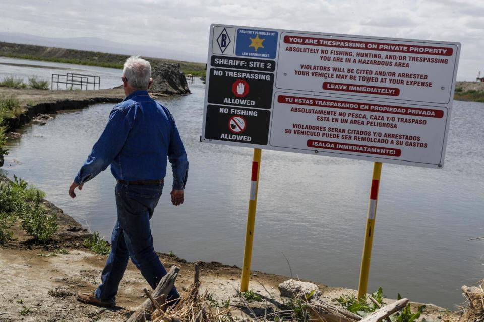 Farmer Charlie Meyer walks toward a levee breach.