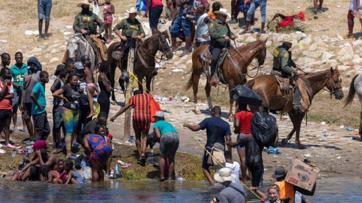 Mounted U.S. Border Patrol agents watch Haitian immigrants on the bank of the Rio Grande in Del Rio, Texas, Sept. 20, 2021 as seen from Ciudad Acuna, Mexico. <span class="copyright">John Moore/Getty Images</span>