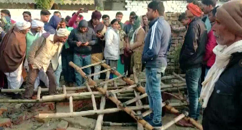 Stunned wedding guests surround the well in India.