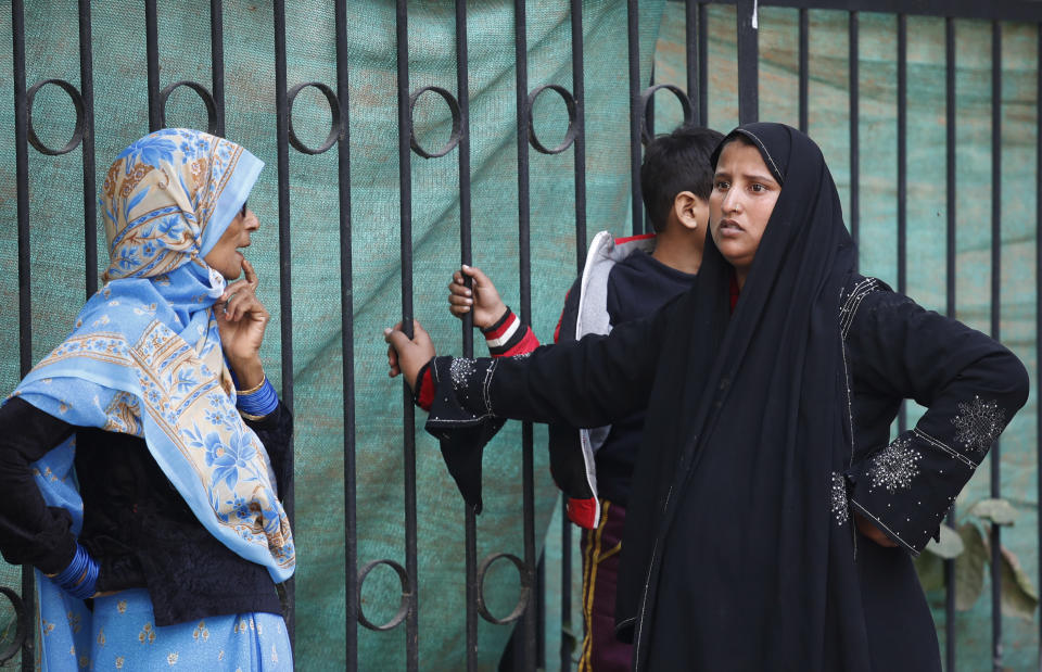 A family waits to collect the body of their relative who died in a fire in New Delhi, India, Sunday, Dec. 8, 2019. Dozens of people died on Sunday in a devastating fire at a building in a crowded grains market area in central New Delhi, police said. (AP Photo/Manish Swarup)