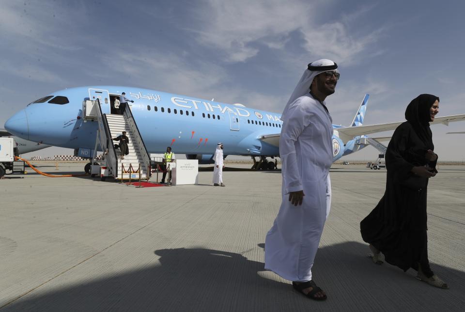 People visit an Ethihad plane during the opening day of Dubai Airshow in Dubai, United Arab Emirates, Sunday, Nov. 17, 2019. The biennial Dubai Airshow has opened as major Gulf airlines reign back big-ticket purchases after a staggering $140 billion in new orders were announced at the 2013 show before global oil prices collapsed.(AP Photo/Kamran Jebreili)