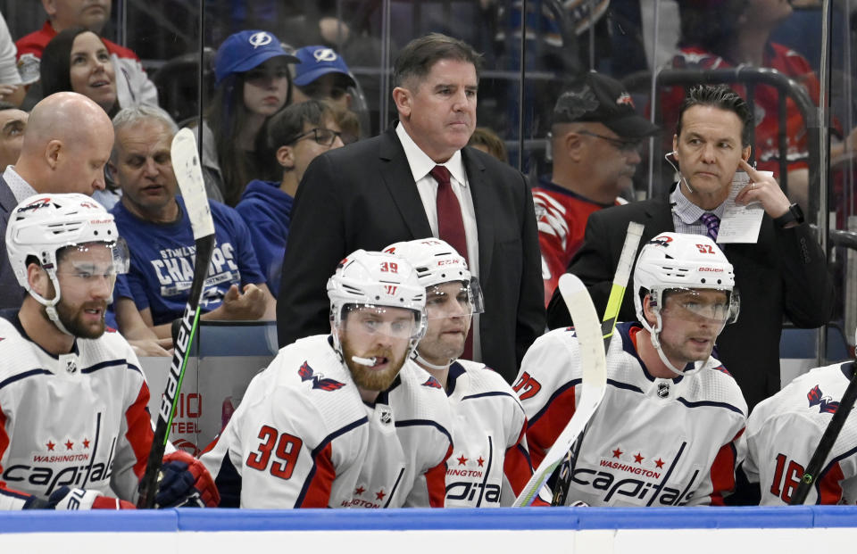 FILE - Washington Capitals head coach Peter Laviolette, top center, looks on during the third period of an NHL hockey game against the Tampa Bay Lightning, March 30, 2023, in Tampa, Fla. The Capitals have decided to move on from coach Laviolette after missing the playoffs. General manager Brian MacLellan announced the decision following the end of the organization's eight-year postseason streak. (AP Photo/Jason Behnken, File)