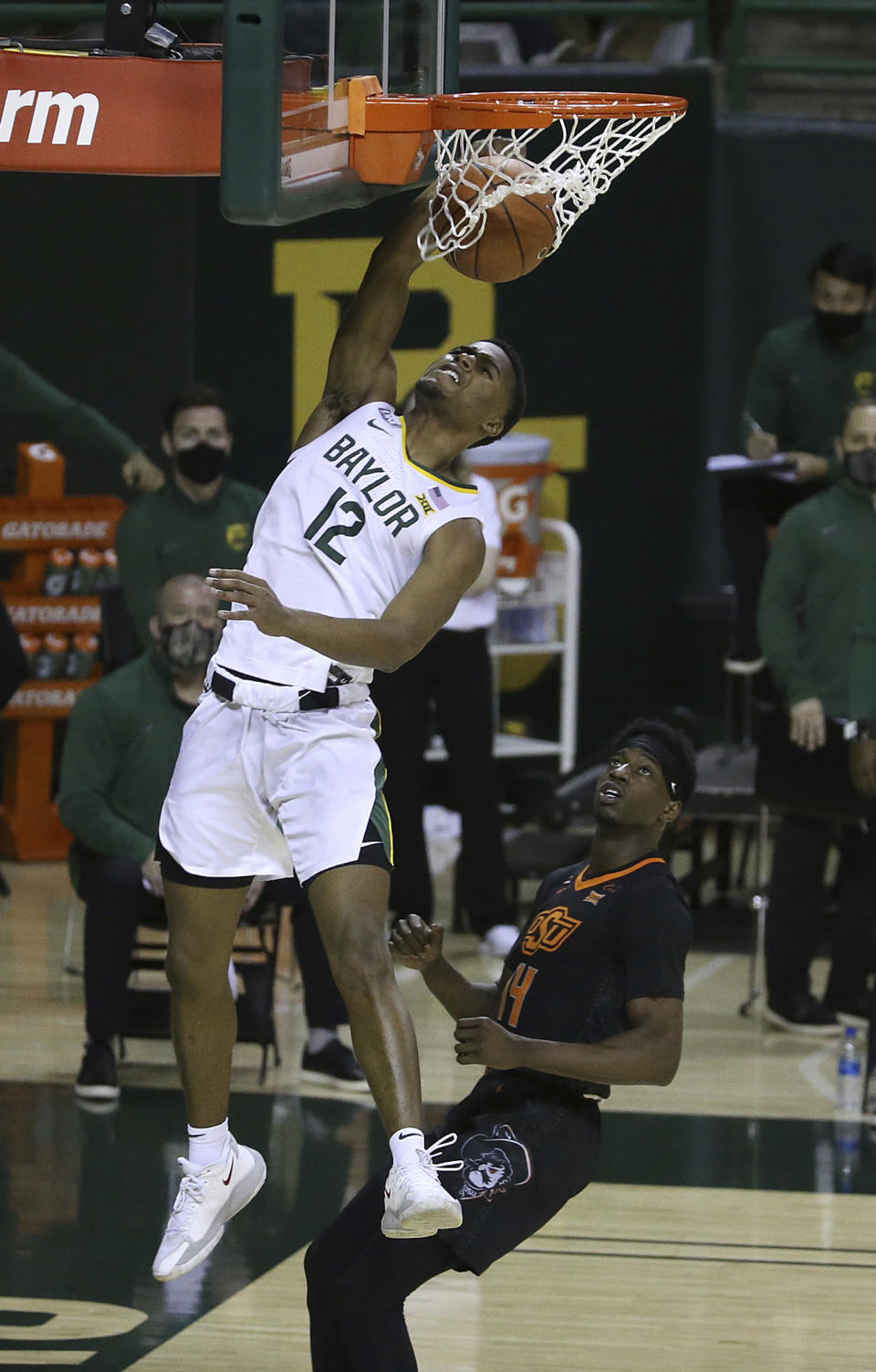 Baylor guard Jared Butler (12) dunks the ball past Oklahoma State guard Bryce Williams (14) in the second half of an NCAA college basketball game, Thursday, March 4, 2021, in Waco, Texas. (AP Photo/Jerry Larson)