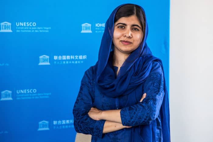 Malala smiles with her arms crossed at an event