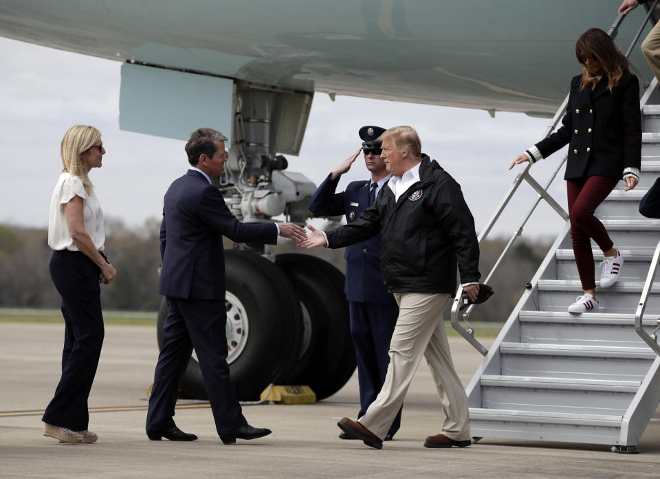 President Donald Trump, with first lady Melania Trump, is greeted by Georgia Gov. Brian Kemp and his wife Marty, as they arrive on Air Force One at Lawson Army Airfield, Fort Benning, Ga., Friday, March 8, 2019, en route to Lee County, Ala., where tornados killed 23 people. (AP Photo/Carolyn Kaster)