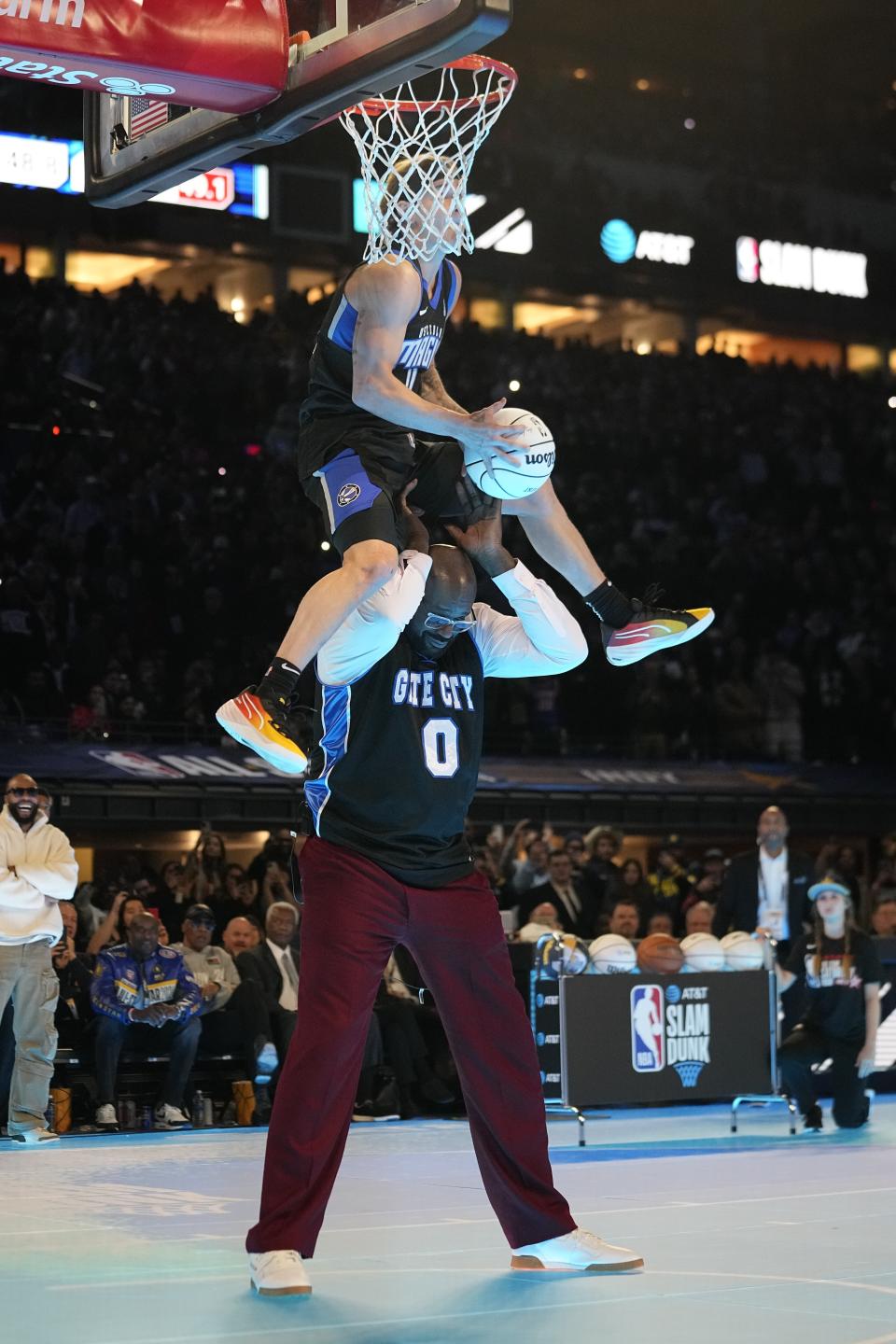 Osceola Magic's Mac McClung dunks over Shaquille O'Neal during the slam dunk competition at the NBA basketball All-Star weekend, Saturday, Feb. 17, 2024, in Indianapolis. (AP Photo/Darron Cummings)