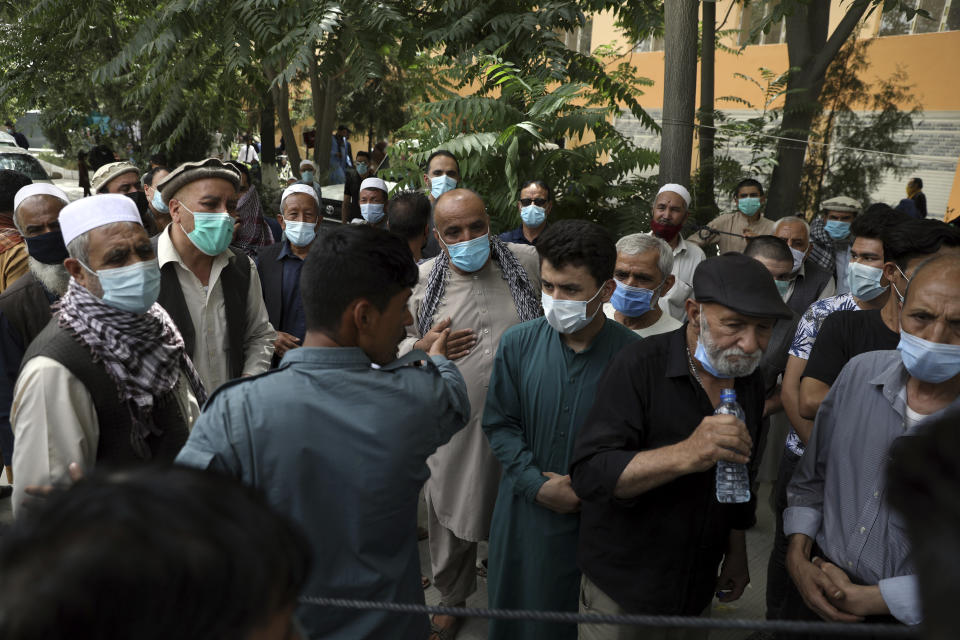 FILE - Residents wearing face masks to help curb the spread of the coronavirus line up to receive the Johnson & Johnson COVID-19 vaccine donated through the U.N.-backed COVAX program at a vaccination center in Kabul, Afghanistan, July 11, 2021. COVAX, created to share coronavirus vaccines fairly, already scaled back its pledge to the world's poor once. Now, to meet even that limited promise, it would have to deliver more than a million doses every hour until the end of the year. (AP Photo/Rahmat Gul, File)