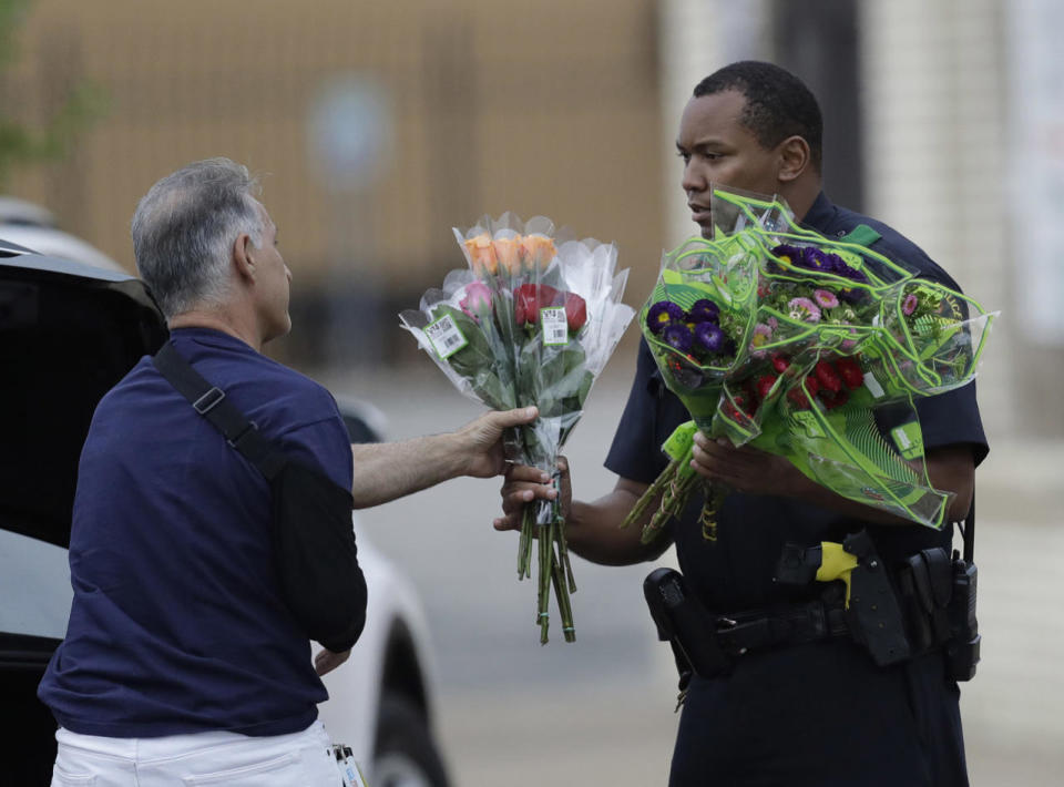 A Dallas police officer receivers flowers at a roadblock outside their headquarters