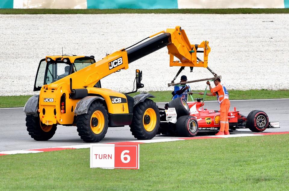 The spare’s on the boot lid: Sebastian Vettel’s broken Ferrari is recovered after his unfortunate tangle with Lance Stroll at the Malaysian Grand Prix