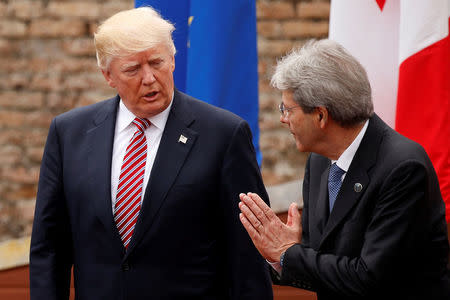 Italy's Prime Minister Paolo Gentiloni (R) talks to U.S. President Donald Trump while posing for a family photo at the start of G7 Summit at Greek Theatre in Taormina, Sicily, Italy, May 26, 2017. REUTERS/Jonathan Ernst