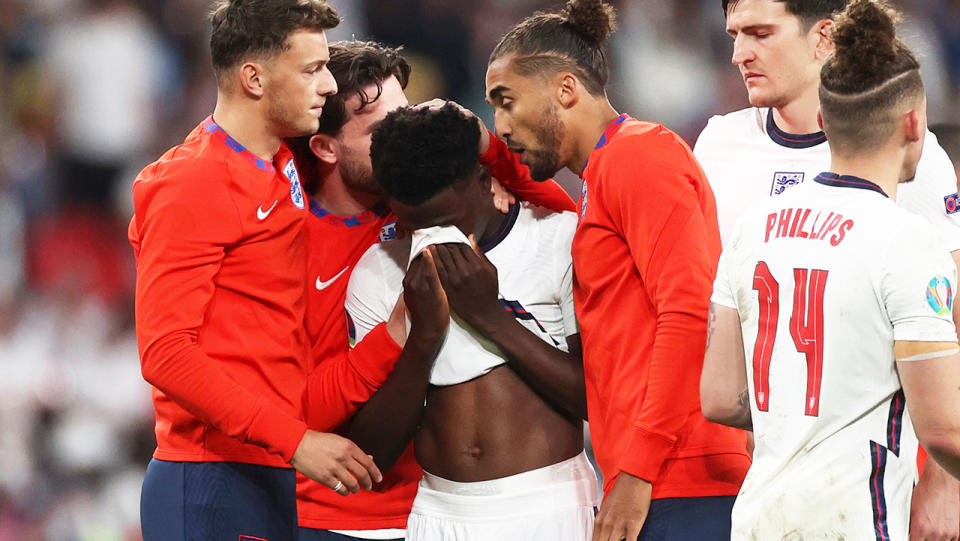 Bukayo Saka (pictured middle) consoled by his teammates after England's loss to Italy in the Euro 2020 final.