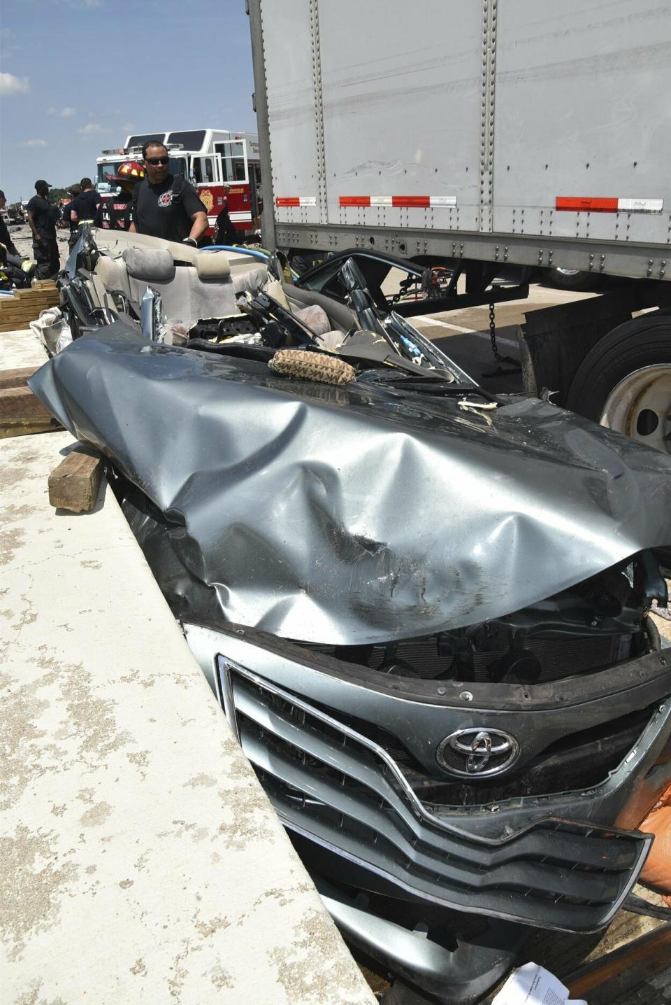 In this image taken Sunday, July 14, 2019, and provided by the Indianapolis Fire Department, emergency personnel work at the scene of fatal crash along Interstate 465 in Indianapolis. Authorities say a woman and her 18-month-old twin daughters died in the fiery, seven-vehicle crash on an Indianapolis freeway. (Battalion Chief Rita L. Reith/Indianapolis Fire Department via AP)