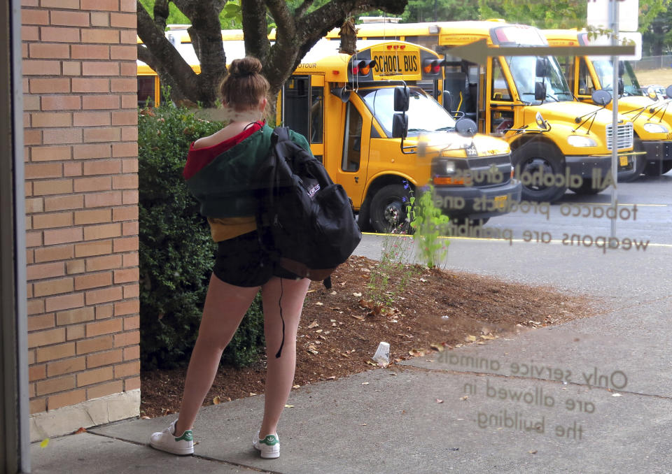 In this Sept. 7, 2018 photo, a student at Grant High School in Portland, Ore., waits for a ride after school. Portland Public Schools relaxed its dress code in 2016 after student complaints that the rules unfairly targeted female students and sexualized their fashion choices. (AP Photo/Gillian Flaccus)