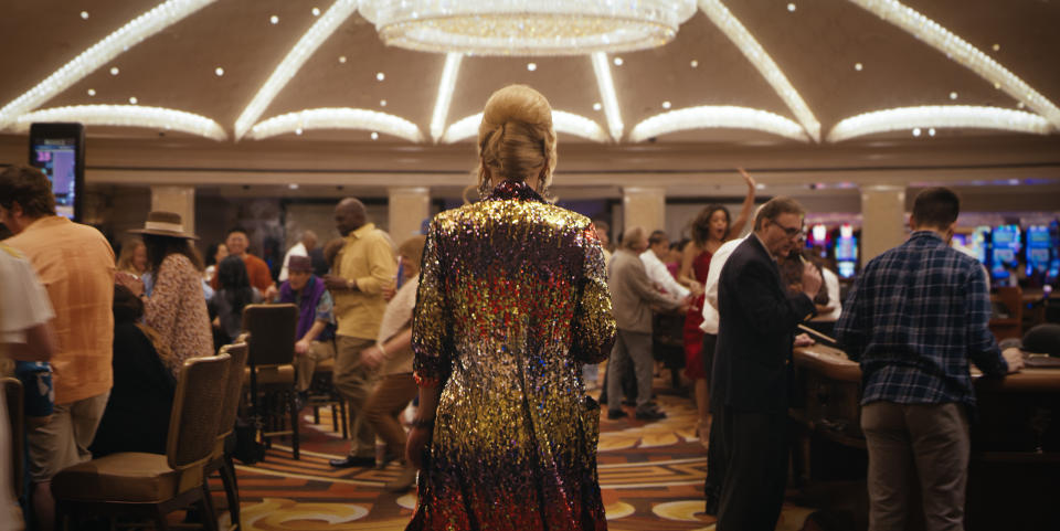 A shot from Episode 1, Season 3 of 'Hacks' of what looks like Deborah Vance (Jean Smart) moving through a Vegas casino in a sequined coat framed from behind. 