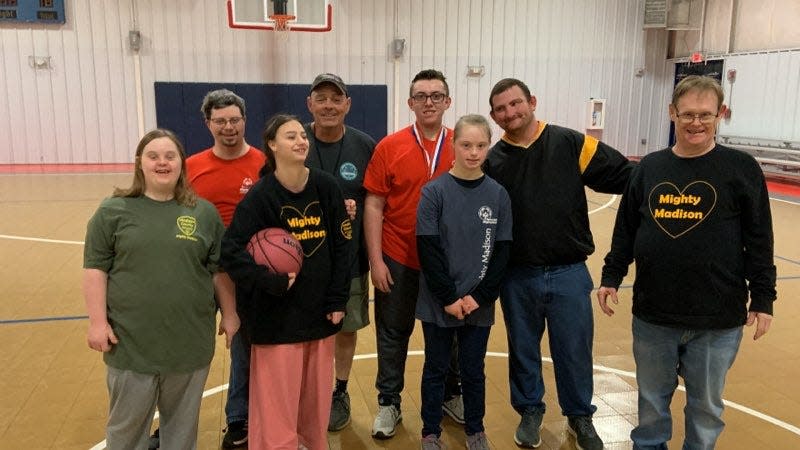 Special Olympics of Madison County athletes pose with their coach James Jones following basketball practice Jan. 31 at Beech Glen Community Center