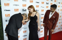 Ismael Kanater, left, a cast member in "The Forgiven," kisses the hand of cast member Jessica Chastain, center, as cast member Mourad Zaoui looks on at the premiere of the film at the 2021 Toronto International Film Festival, Saturday, Sept. 11, 2021, in Toronto. (AP Photo/Chris Pizzello)