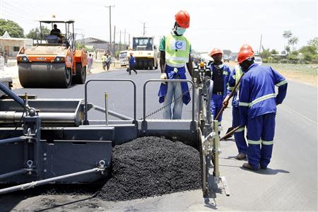 Labourers carry out surfacing work on a road near the Zambian capital Lusaka November 15, 2013. REUTERS/Mackson Wasamunu