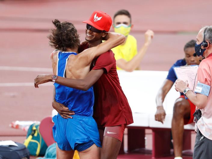 Gianmarco Tamberi and Mutaz Essa Barshim embrace after deciding to split gold.