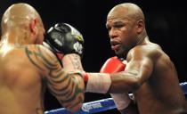 US boxer Floyd Mayweather Jr. (R) and Puerto Rico's Miguel Cotto (L) duel it out on May 5, 2012 in Las Vegas, Nevada, during their Super Welterweight Championship fight. Mayweather Jr. defeated Cotto on a unanimous decision in the 12-roud bout. AFP PHOTO/Frederic J. BROWNFREDERIC J. BROWN/AFP/GettyImages