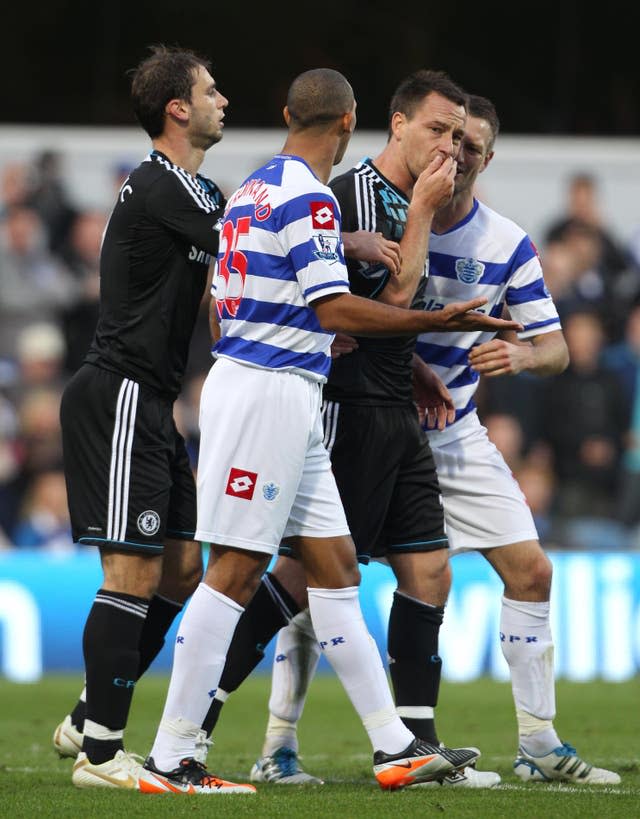 John Terry, centre right, covers his mouth as he speaks to Anton Ferdinand, centre left