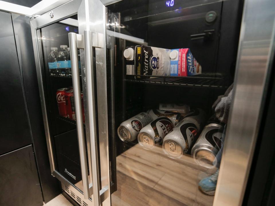 A fridge with tinted windows and drinks inside.