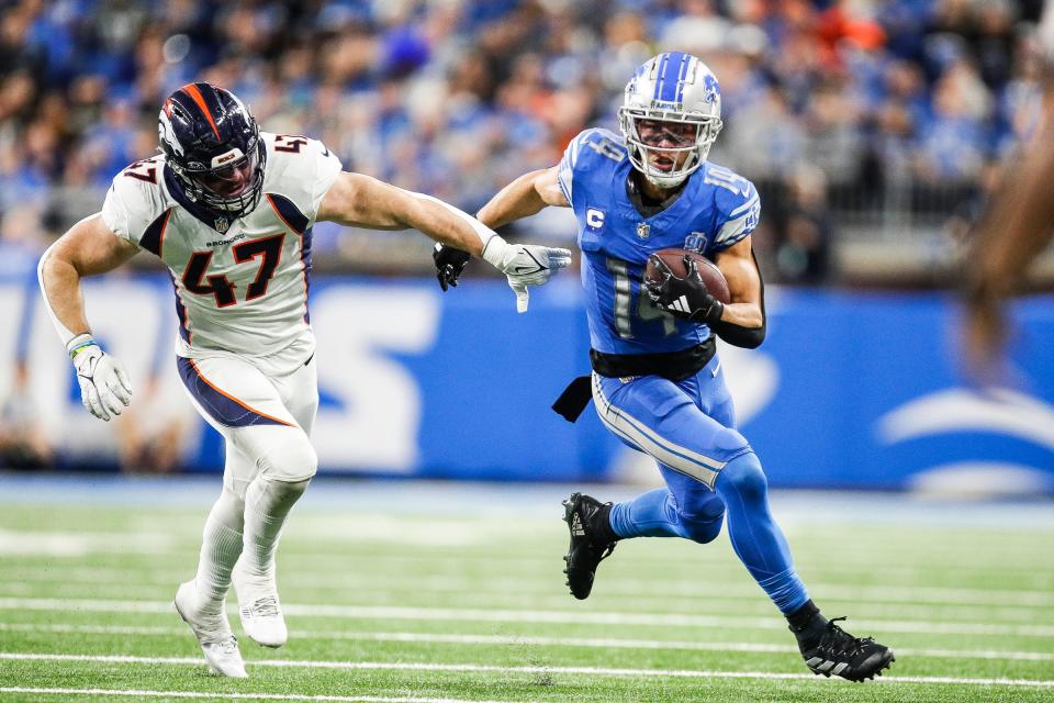 Detroit Lions wide receiver Amon-Ra St. Brown (14) runs against Denver Broncos linebacker Josey Jewell (47) during the second half at Ford Field in Detroit on Saturday, Dec. 16, 2023.