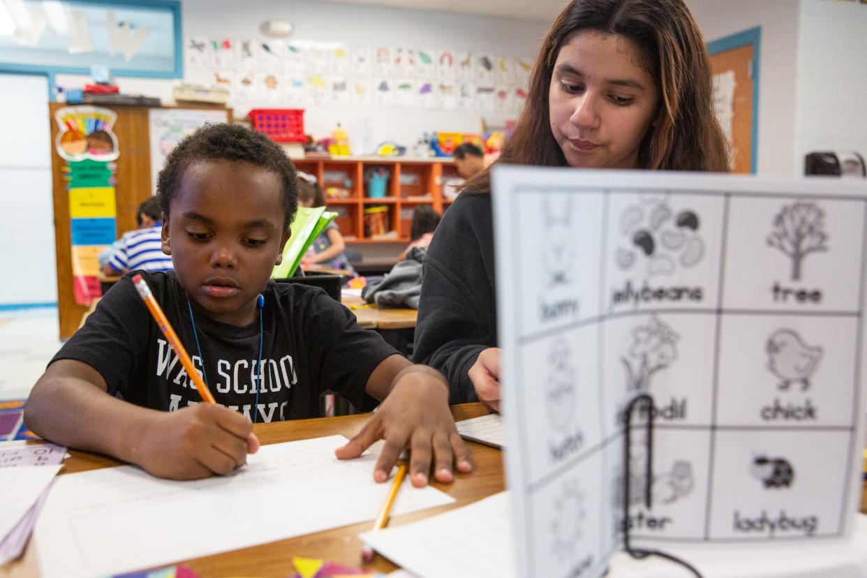 Fifth grade student Viviana Riojas helps first grade student Khyrie Guy with writing sentences during an aftercare program at Garcia Elementary School on Thursday, March 28, 2024, in Corpus Christi, Texas.