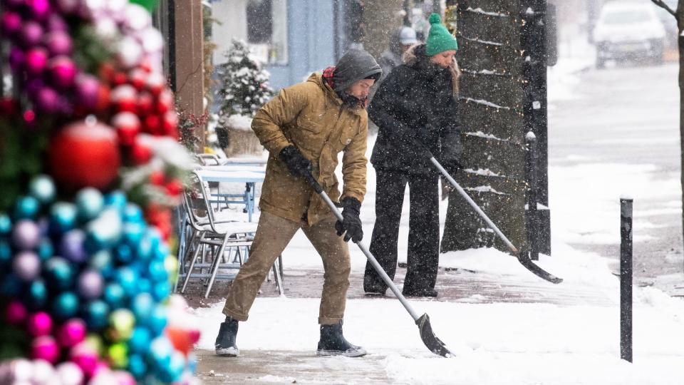 Scott Whalen, owner of Wild & Co. cafe, left, and Kristen Stang, a manager of Sabrina's Café, shovel snow from the sidewalk of Haddon Ave. in Collingswood on Friday, January 19, 2024.