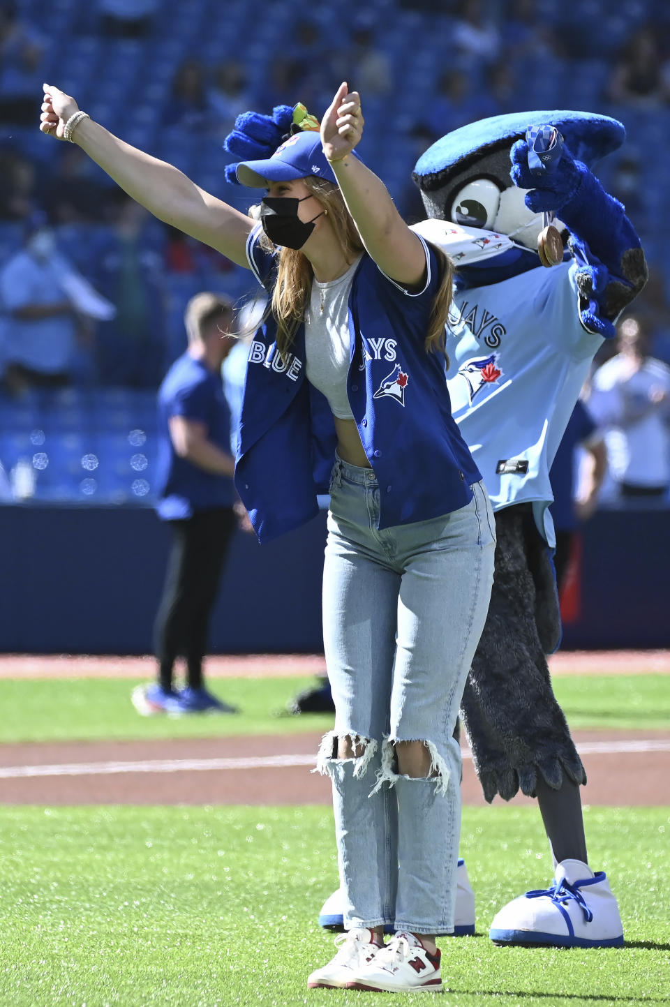 Canadian Olympian Penny Oleksiak throws out the ceremonial first pitch before the start of a baseball game between the Toronto Blue Jays and the Minnesota Twins in Toronto on Saturday, Sept. 18, 2021. (Jon Blacker/The Canadian Press via AP)