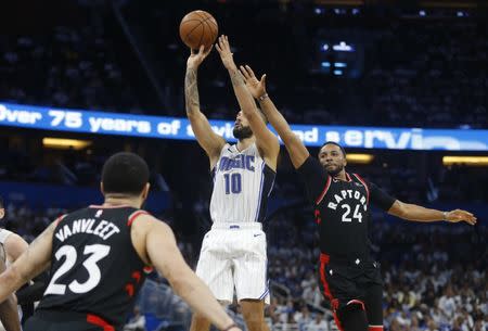 Apr 19, 2019; Orlando, FL, USA; Orlando Magic guard Evan Fournier (10) shoots between Toronto Raptors forward Norman Powell (24) and guard Fred VanVleet (23) during the second half of game three of the first round of the 2019 NBA Playoffs at Amway Center. Mandatory Credit: Reinhold Matay-USA TODAY Sports