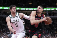 Chicago Bulls' Nikola Vucevic (9) drives to the basket as Milwaukee Bucks' Brook Lopez defends during the first half of an NBA basketball game Thursday, Feb. 16, 2023, in Chicago. (AP Photo/Charles Rex Arbogast)