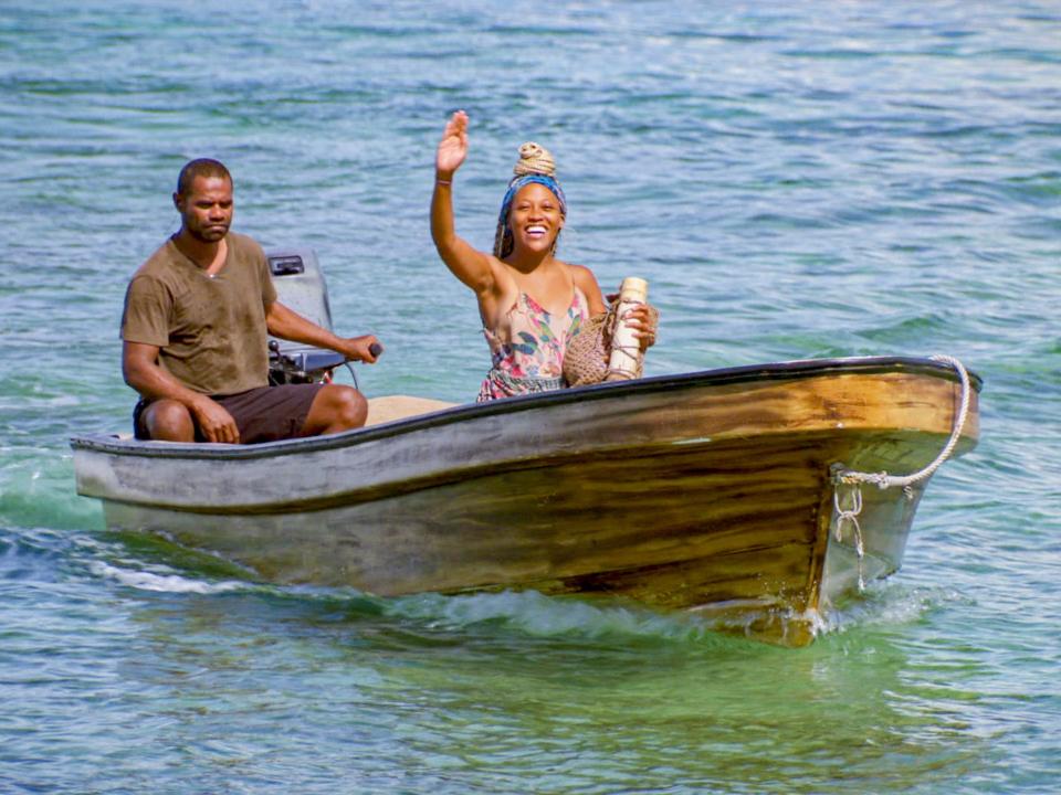 Lauren-Ashley Beck riding a smaller boat and waving on survivor