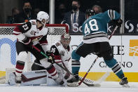 Arizona Coyotes goaltender Darcy Kuemper (35) blocks a shot by San Jose Sharks center Tomas Hertl (48) as Oliver Ekman-Larsson (23) defends during the second period of an NHL hockey game Friday, May 7, 2021, in San Jose, Calif. (AP Photo/Tony Avelar)