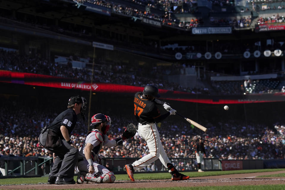 San Francisco Giants' Marco Luciano, right, hits a double in front of umpire Junior Valentine, left, and Boston Red Sox catcher Connor Wong, center, during the fourth inning of a baseball game in San Francisco, Saturday, July 29, 2023. (AP Photo/Jeff Chiu)
