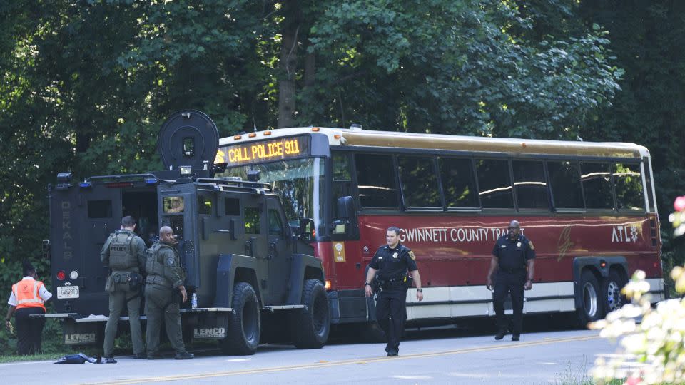 A hijacked commuter bus sits in the road where it was stopped after a lengthy police chase Tuesday. - Ben Gray/AP