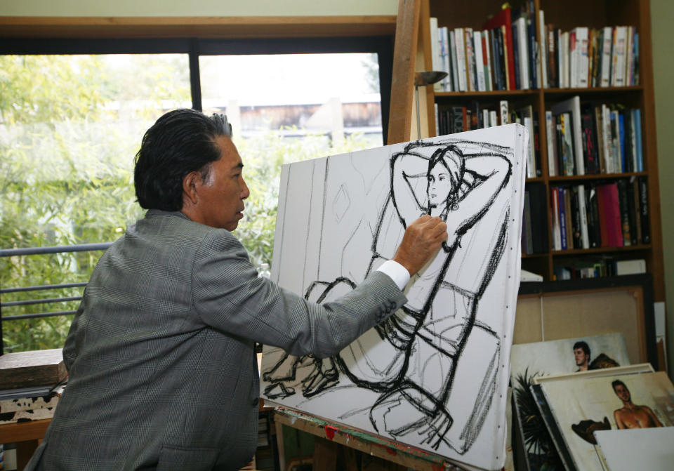 ARCHIVO – En esta fotografía de archivo del 24 de marzo de 2009 el diseñador de modas japonés Kenzo Takada hace un dibujo en su casa en París. La familia del diseñador informó el domingo 4 de octubre de 2020 que Takada falleció por complicaciones de COVID-19 en un hospital de Neuilly-sur-Seine, cerca de París. Tenía 81 años. (Foto AP/Jacques Brinon, archivo)