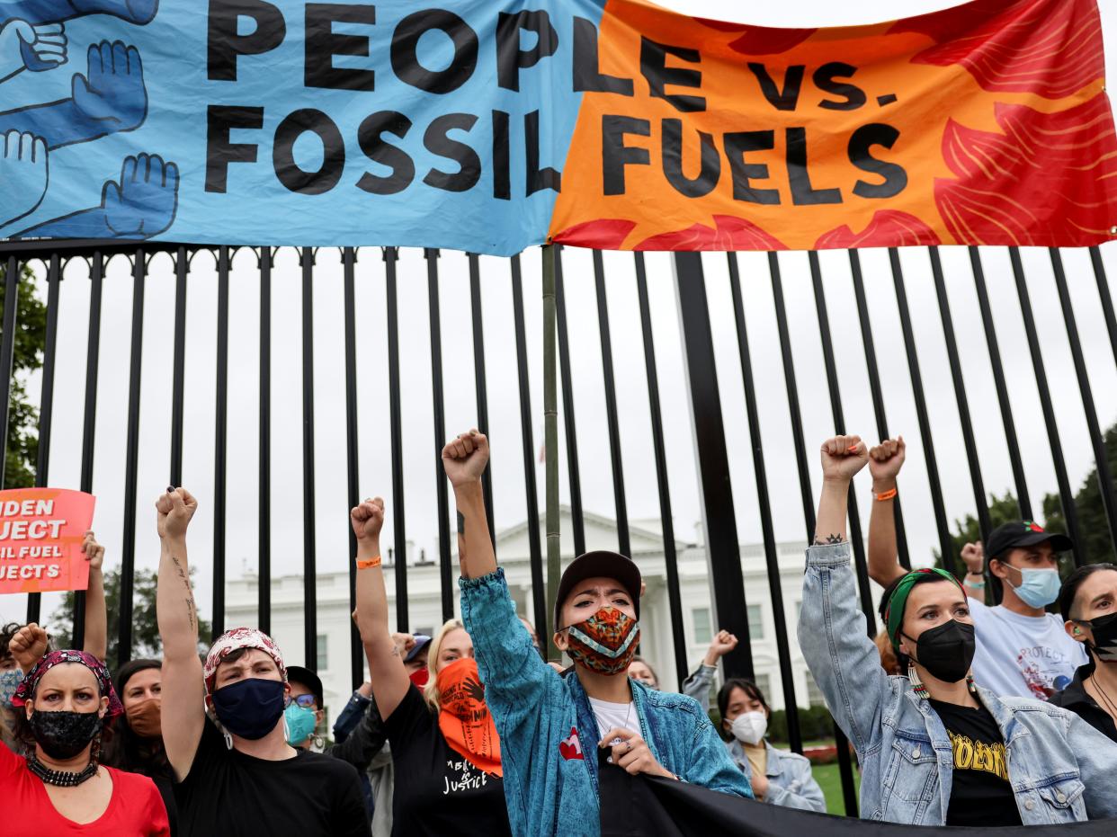 People raise their fists at a climate change protest outside the White House