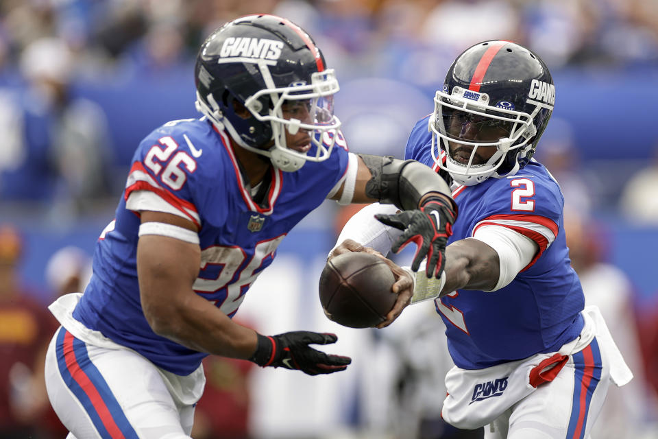 New York Giants quarterback Tyrod Taylor (2) hands off the ball to running back Saquon Barkley (26) during the third quarter of an NFL football game, Sunday, Oct. 22, 2023, in East Rutherford, N.J. (AP Photo/Adam Hunger)