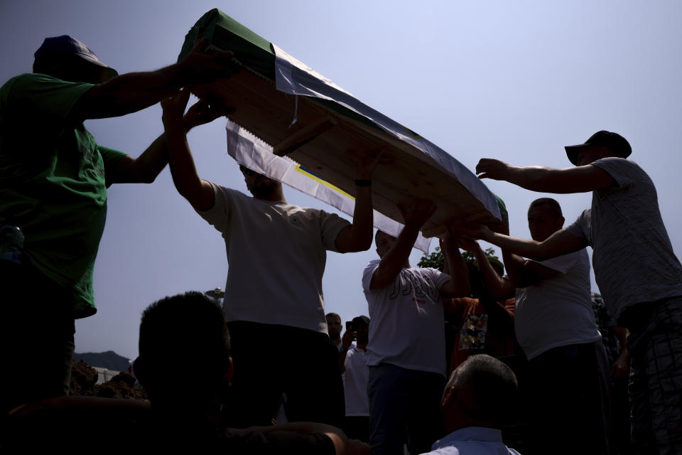 Bosnian muslim men carry the coffins containing the remains of 30 newly identified victims of the Srebrenica Genocide in Potocari, Bosnia, Tuesday, July 11, 2023. Thousands gather in the eastern Bosnian town of Srebrenica to commemorate the 28th anniversary on Monday of Europe's only acknowledged genocide since World War II. (AP Photo/Armin Durgut)