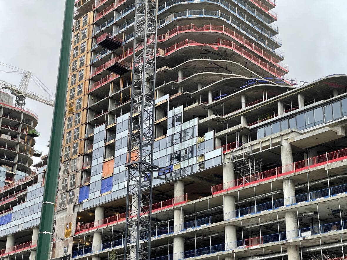 A crane dropped its load onto a building under construction at the Oakridge redevelopment area on Wednesday, according to emergency crews. (Gian Paolo Mendoza/CBC - image credit)