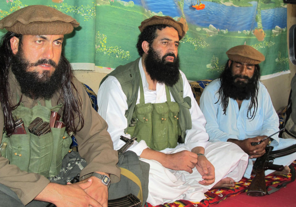 FILE - In this Saturday, Oct. 5, 2013 file photo, Pakistani Taliban spokesman Shahidullah Shahid, center, flanked by his bodyguards, talks to reporters at an undisclosed location in Pakistani tribal area of Waziristan along Afghanistan border. The Pakistani Taliban announced Saturday that the group will observe a one-month cease-fire as part of efforts to negotiate a peace deal with the government, throwing new life into a foundering peace process. Spokesman Shahidullah Shahid said in a statement emailed to reporters that the top leadership of the militant group has instructed all of its units to comply with the cease-fire. (AP Photo/Ishtiaq Mahsud, File)