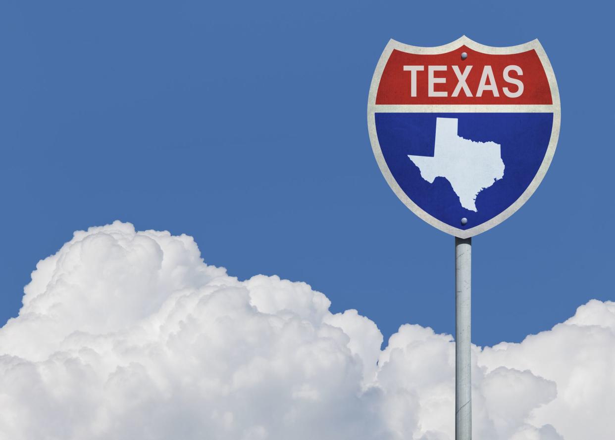 Highway sign for Interstate road in Texas with map in front of clouds