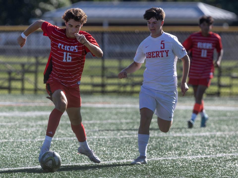 Jackson Liberty's Dylan Kasnowski (white shirt, defending Neptune's Nate Kerr) had two goals when the Lions defeated Neptune 4-0 in boys soccer, lifting them to a 2-0 record in Group 1 in Shore Conference Tournament pool play in Neptune Sept. 14, 2023.