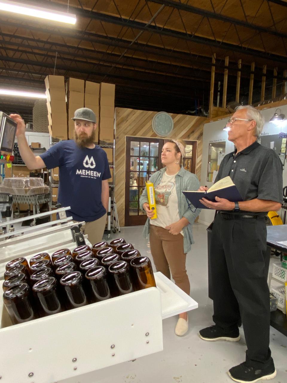 Waynesville Soda Jerks owners Megan Brown and Chris Allen with advisor John Forrester at the bottling facility in Waynesville.